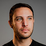 A man in a black shirt with blue eyes.