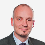 A man in a suit and tie is posing for a photo.